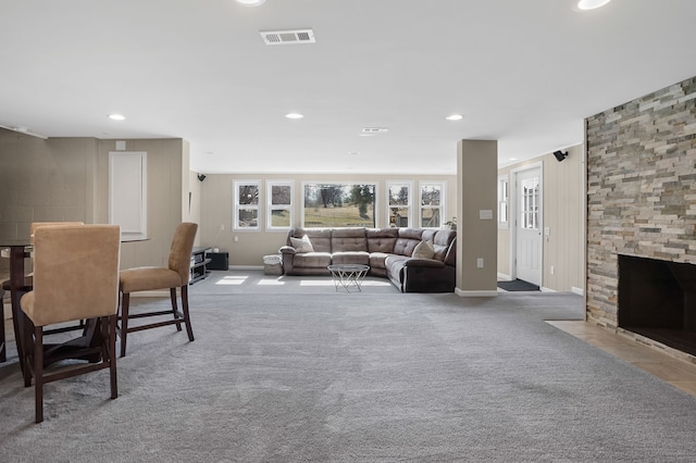 living area with recessed lighting, visible vents, carpet floors, and a stone fireplace