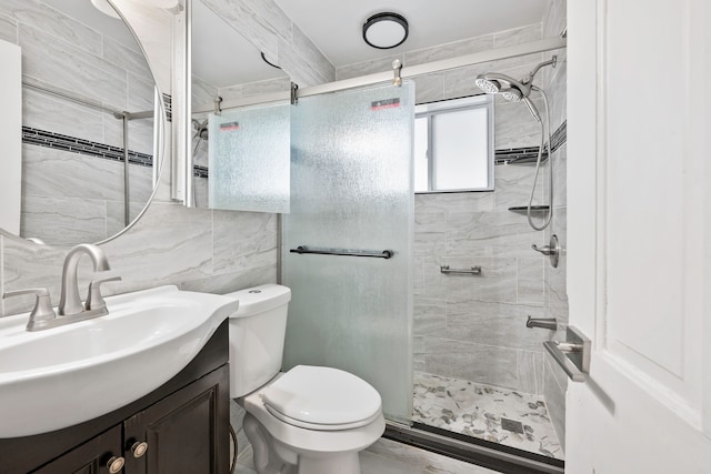 bathroom featuring vanity, decorative backsplash, a shower stall, tile walls, and toilet