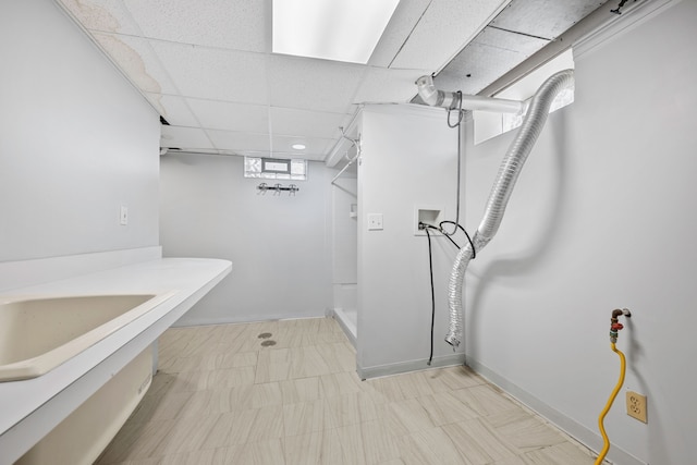 bathroom featuring a paneled ceiling, a stall shower, and baseboards