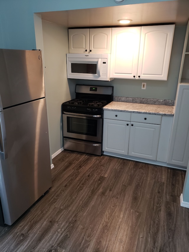 kitchen with white cabinets, dark wood-style floors, and appliances with stainless steel finishes