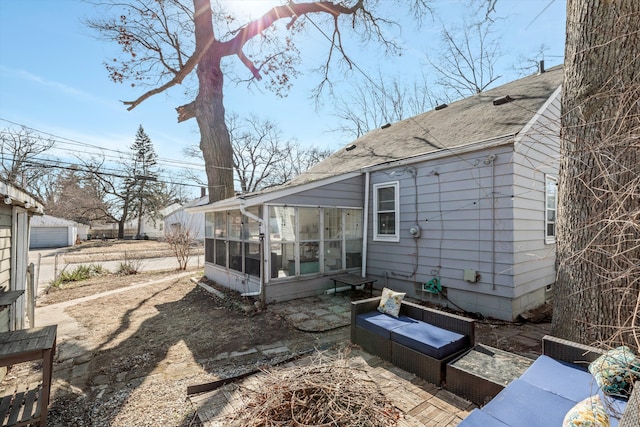 back of property featuring an outdoor hangout area, a shingled roof, and a sunroom