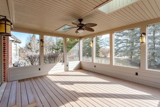 unfurnished sunroom with a skylight and ceiling fan