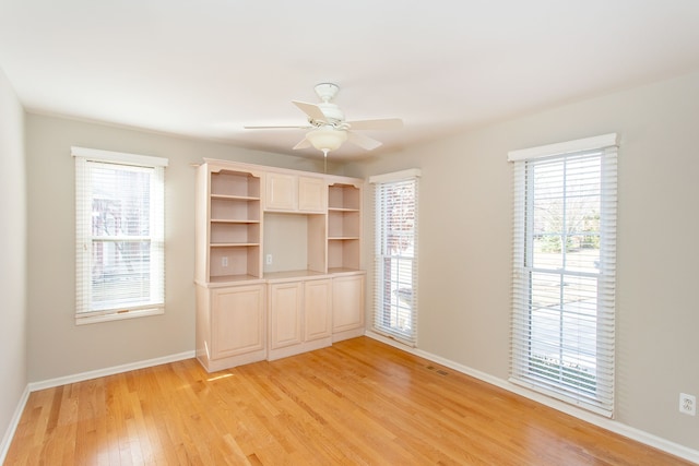 unfurnished bedroom featuring light wood finished floors, a ceiling fan, and baseboards