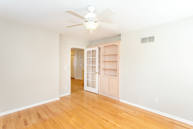 empty room featuring visible vents, light wood-style flooring, french doors, baseboards, and ceiling fan