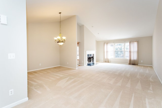 unfurnished living room with baseboards, a chandelier, a fireplace with flush hearth, light carpet, and high vaulted ceiling