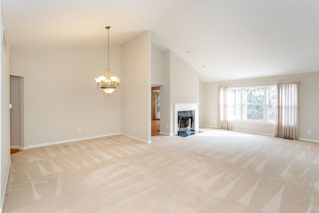 unfurnished living room featuring baseboards, a fireplace with flush hearth, light carpet, an inviting chandelier, and high vaulted ceiling