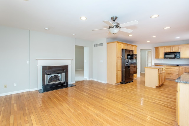 kitchen featuring visible vents, black appliances, open floor plan, and light brown cabinets