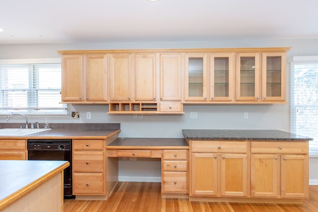 kitchen featuring light brown cabinetry, a healthy amount of sunlight, black dishwasher, and a sink