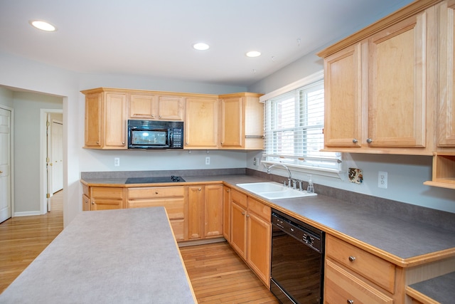 kitchen with a sink, light wood-type flooring, black appliances, and light brown cabinets