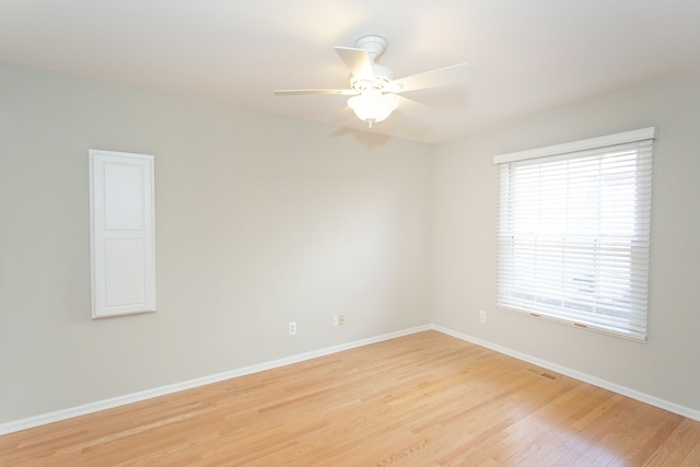 spare room featuring visible vents, baseboards, a ceiling fan, and light wood finished floors