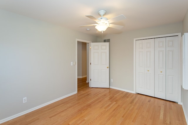 unfurnished bedroom featuring visible vents, baseboards, ceiling fan, light wood-style flooring, and a closet