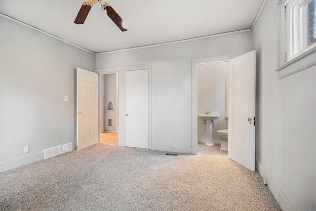 unfurnished bedroom featuring visible vents, carpet flooring, a ceiling fan, and connected bathroom