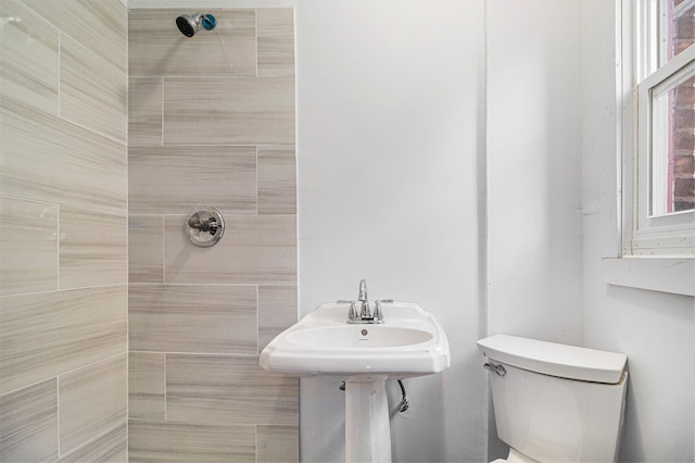 bathroom featuring toilet and tiled shower