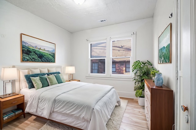 bedroom featuring visible vents, baseboards, and light wood-style floors