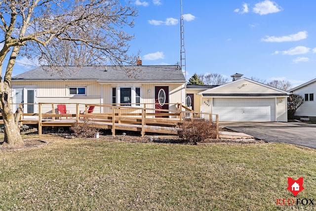 view of front of property with a deck, a front lawn, aphalt driveway, a garage, and a chimney