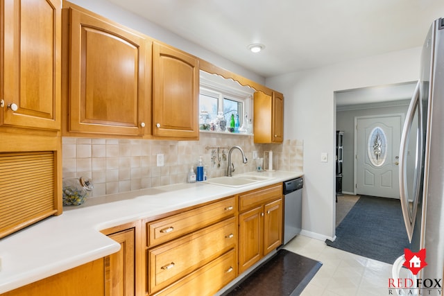 kitchen featuring baseboards, light countertops, decorative backsplash, stainless steel appliances, and a sink