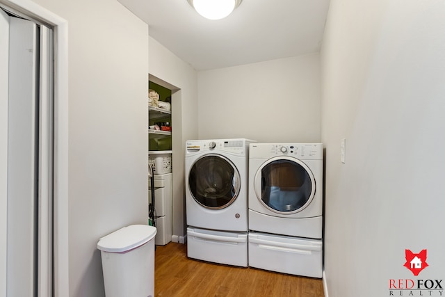 clothes washing area featuring laundry area, washing machine and dryer, and light wood-style floors