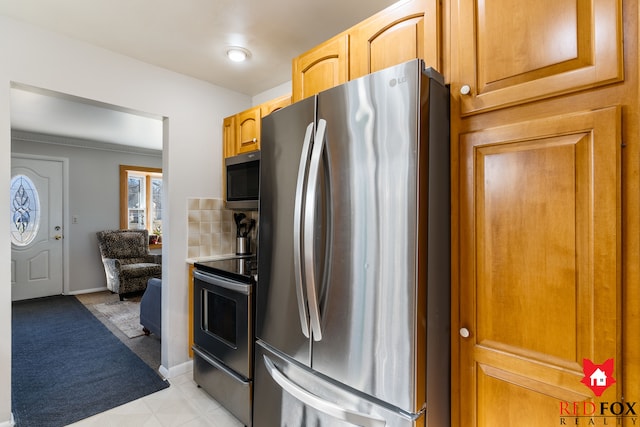 kitchen featuring baseboards, appliances with stainless steel finishes, and light countertops