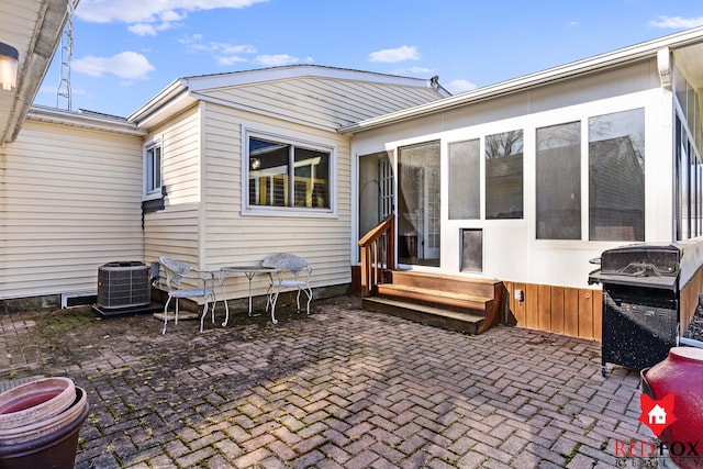 rear view of house with a patio area, entry steps, and central AC