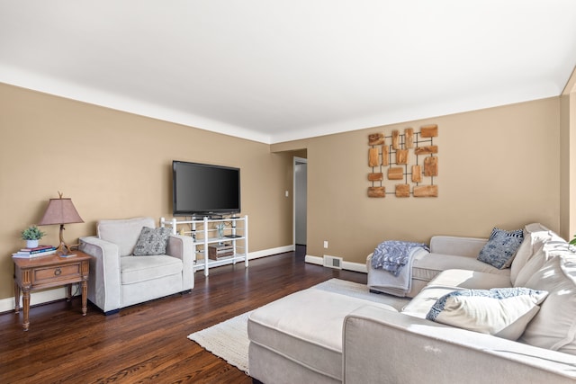 living room with wood finished floors, visible vents, and baseboards