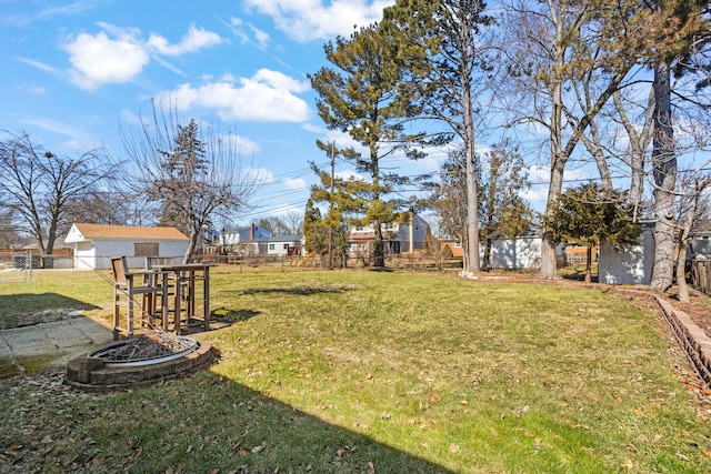 view of yard featuring an outdoor fire pit and fence