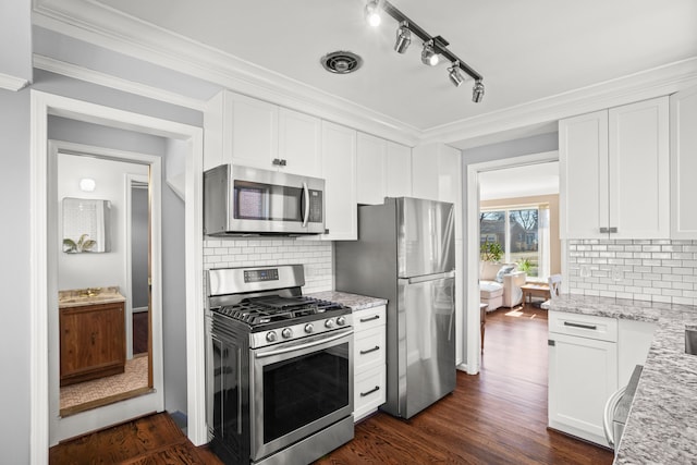 kitchen featuring light stone countertops, appliances with stainless steel finishes, dark wood-style floors, and crown molding