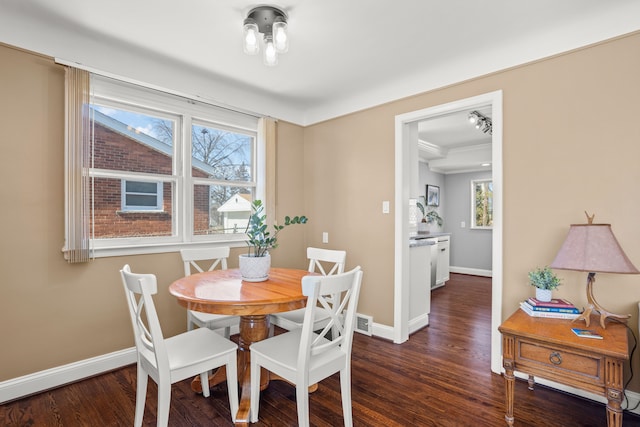 dining space with baseboards, a healthy amount of sunlight, and wood finished floors