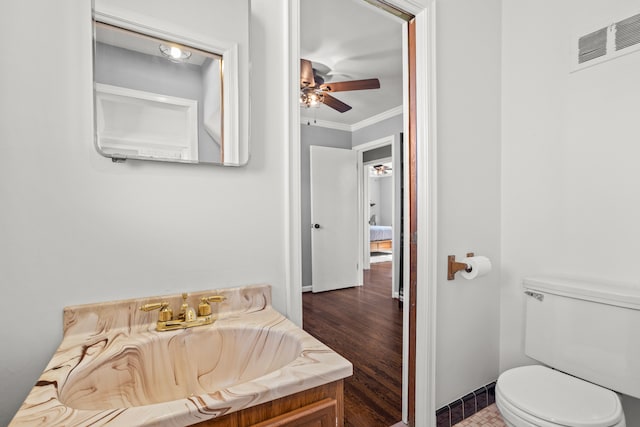 bathroom with visible vents, a sink, ceiling fan, crown molding, and toilet