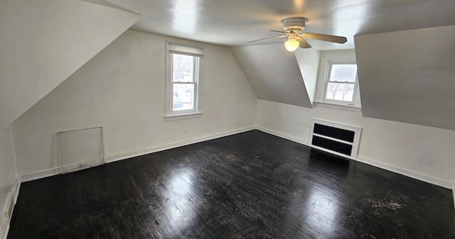 bonus room featuring a wealth of natural light, dark wood finished floors, baseboards, and vaulted ceiling