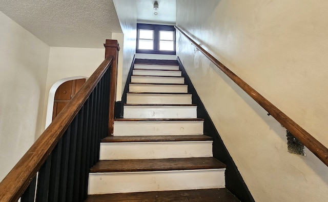 stairs with a textured ceiling