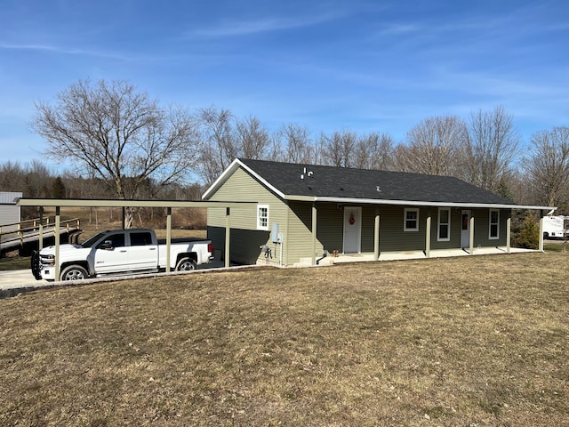 ranch-style house featuring roof with shingles, a porch, a detached carport, and a front lawn