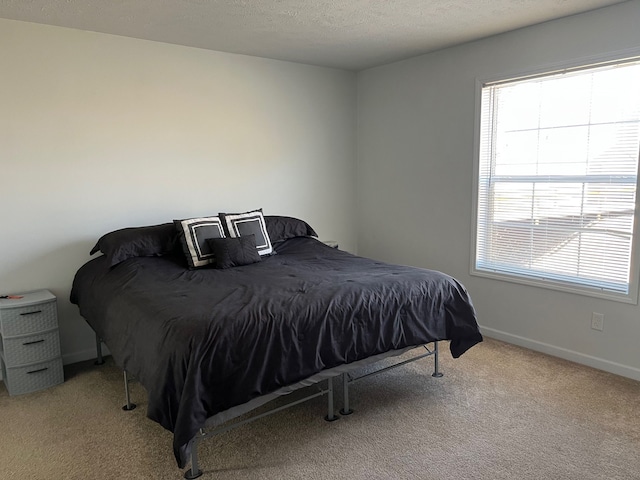 carpeted bedroom with baseboards and a textured ceiling