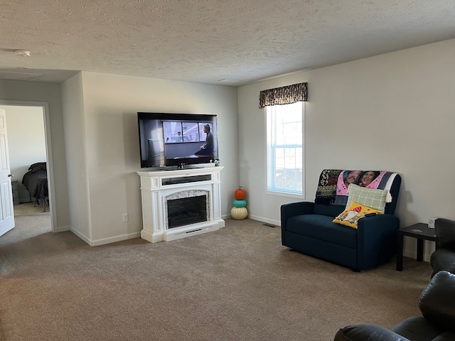 carpeted living area with baseboards, a textured ceiling, and a fireplace