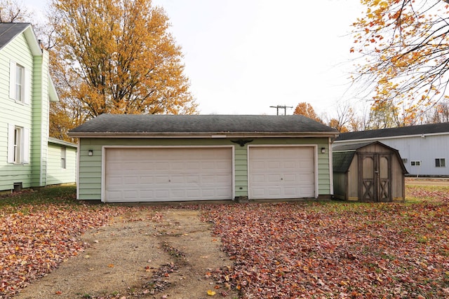 detached garage featuring a shed