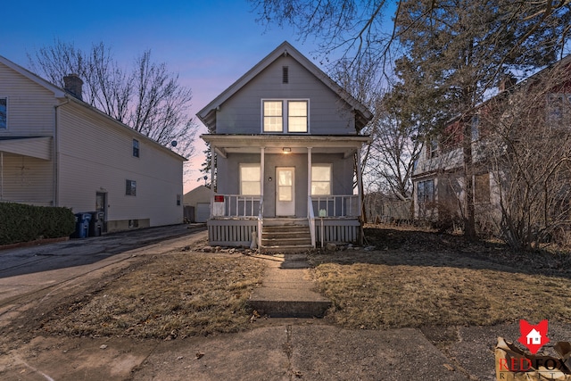 view of front facade with a porch, a garage, and driveway