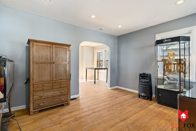 home office with recessed lighting, baseboards, arched walkways, and light wood-style floors