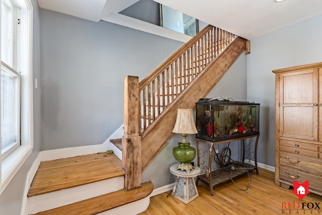 staircase featuring baseboards and wood finished floors