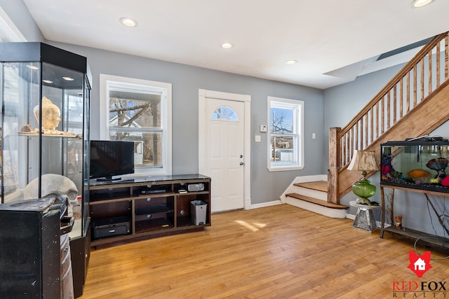 foyer with recessed lighting, stairway, baseboards, and light wood-style floors