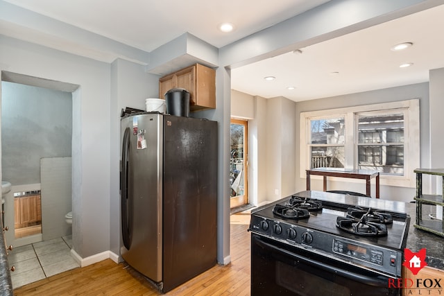 kitchen with light wood-style flooring, black gas range, freestanding refrigerator, recessed lighting, and baseboards