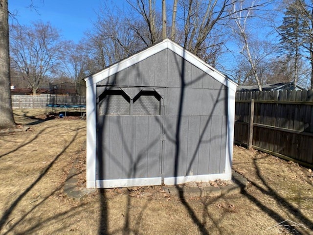 view of shed featuring a trampoline and a fenced backyard