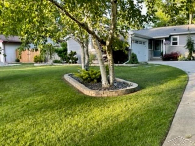 ranch-style home featuring a front lawn and a garage