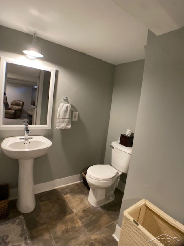 bathroom with toilet and baseboards