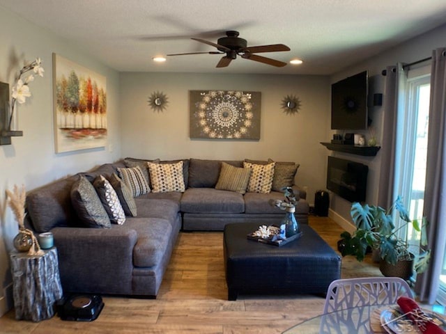 living area featuring recessed lighting, wood finished floors, a fireplace, and ceiling fan