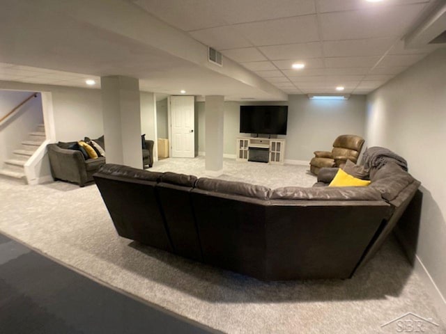 carpeted living area with stairway, visible vents, baseboards, recessed lighting, and a paneled ceiling