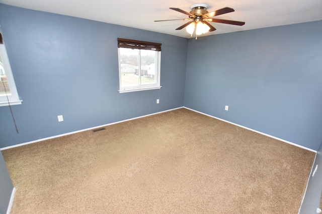 spare room featuring visible vents, baseboards, carpet, and a ceiling fan