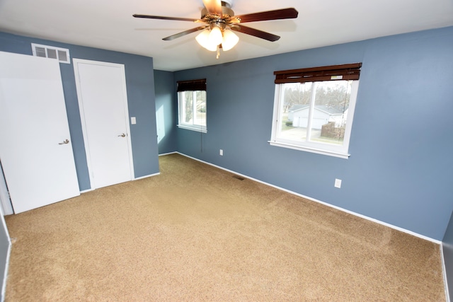 unfurnished bedroom featuring a ceiling fan, carpet, and visible vents