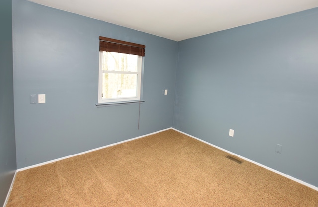 empty room featuring visible vents, baseboards, and carpet flooring