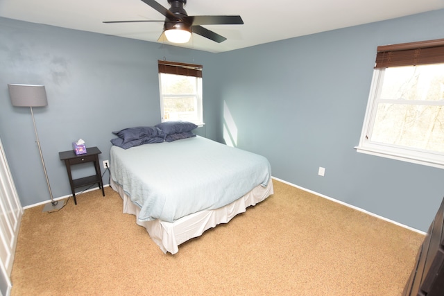 bedroom featuring a ceiling fan, baseboards, and light carpet