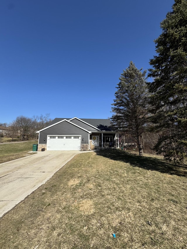 view of front facade featuring driveway, an attached garage, and a front lawn