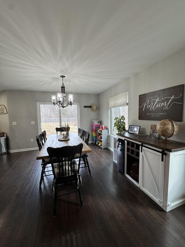 dining room featuring a chandelier, baseboards, and dark wood-style floors